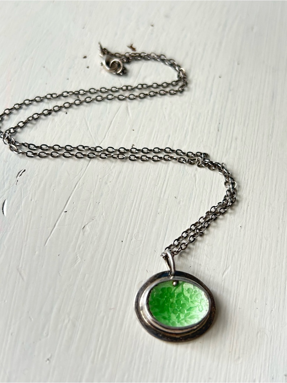 This sterling 925 pendant has a vibrant green inlay with detailed floral pattern